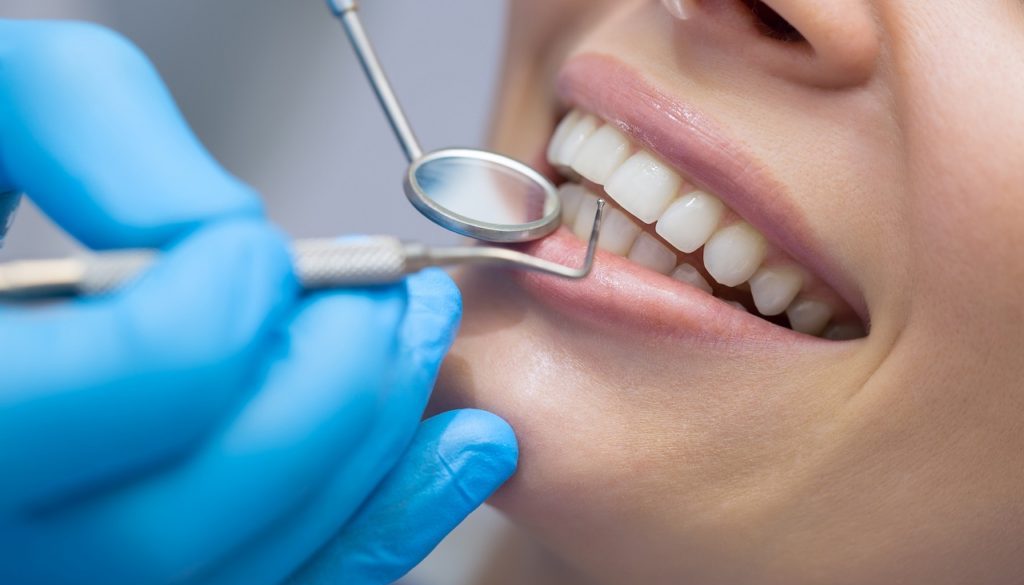 Girl with beautiful white teeth on reception at the doctor dentist.